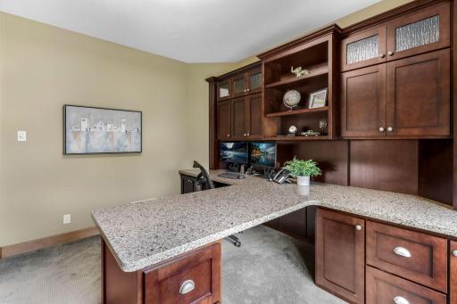 Built-in workstation features quartz tops, decorative glass doors, file drawers, storage and open bookshelves
