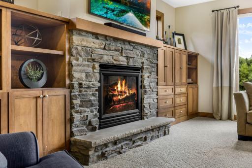 Gas fireplace with cultured stone surround and raised hearth