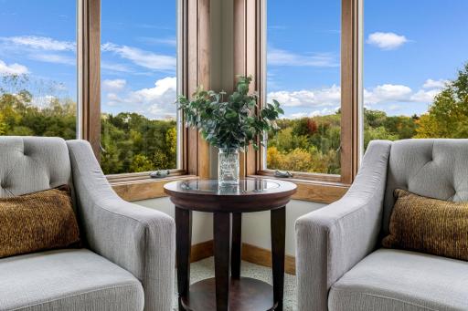 Sitting area features large windows with treetop views