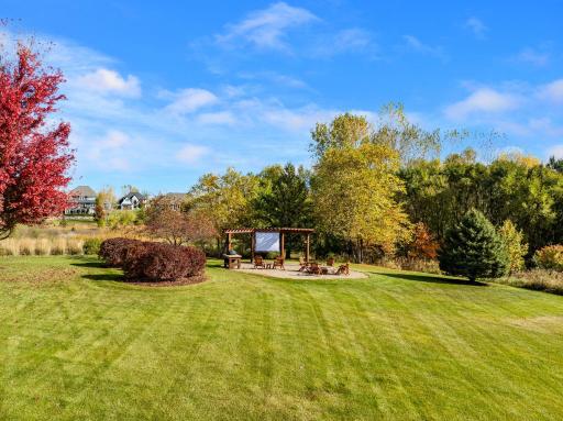 Outside, enjoy lush landscaping, a paver patio with a built-in grill, a pergola, and a fire pit. This yard is something else - ready for all your ideas.