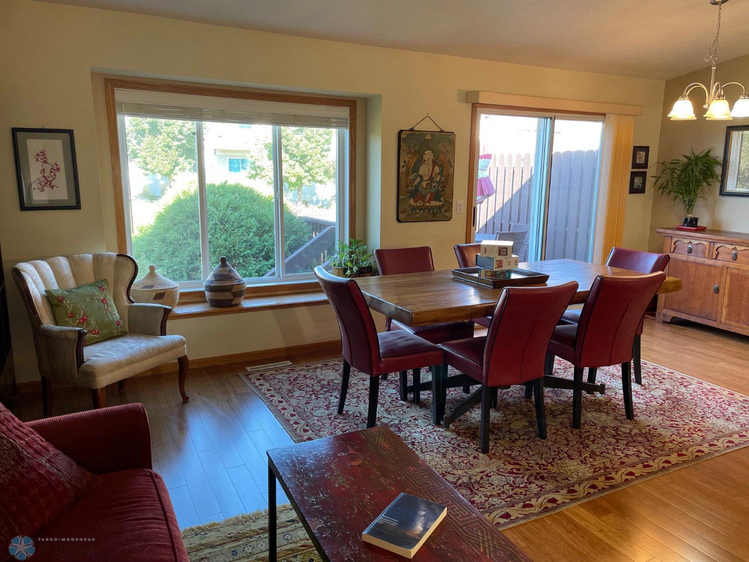 Vaulted living room view to dining area and patio door. Solid bamboo hardwood floor.