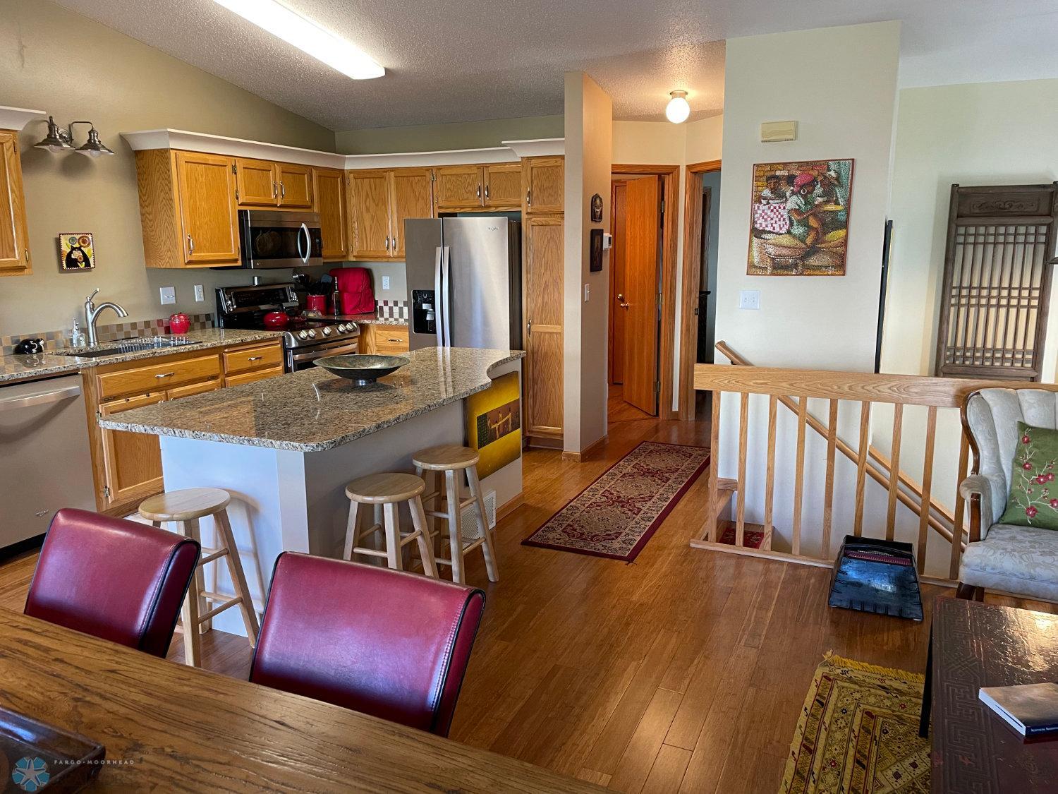 View from living room and dining area to kitchen and the stairway. Solid bamboo hardwood floor.
