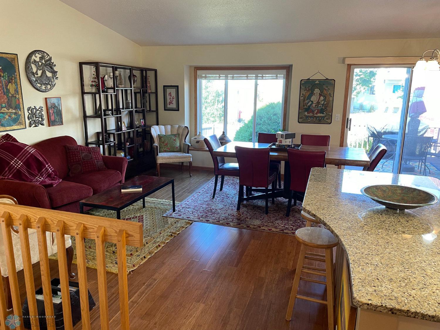 Vaulted living room, dining area, and kitchen island viewed from stairs. Solid bamboo hardwood floor.