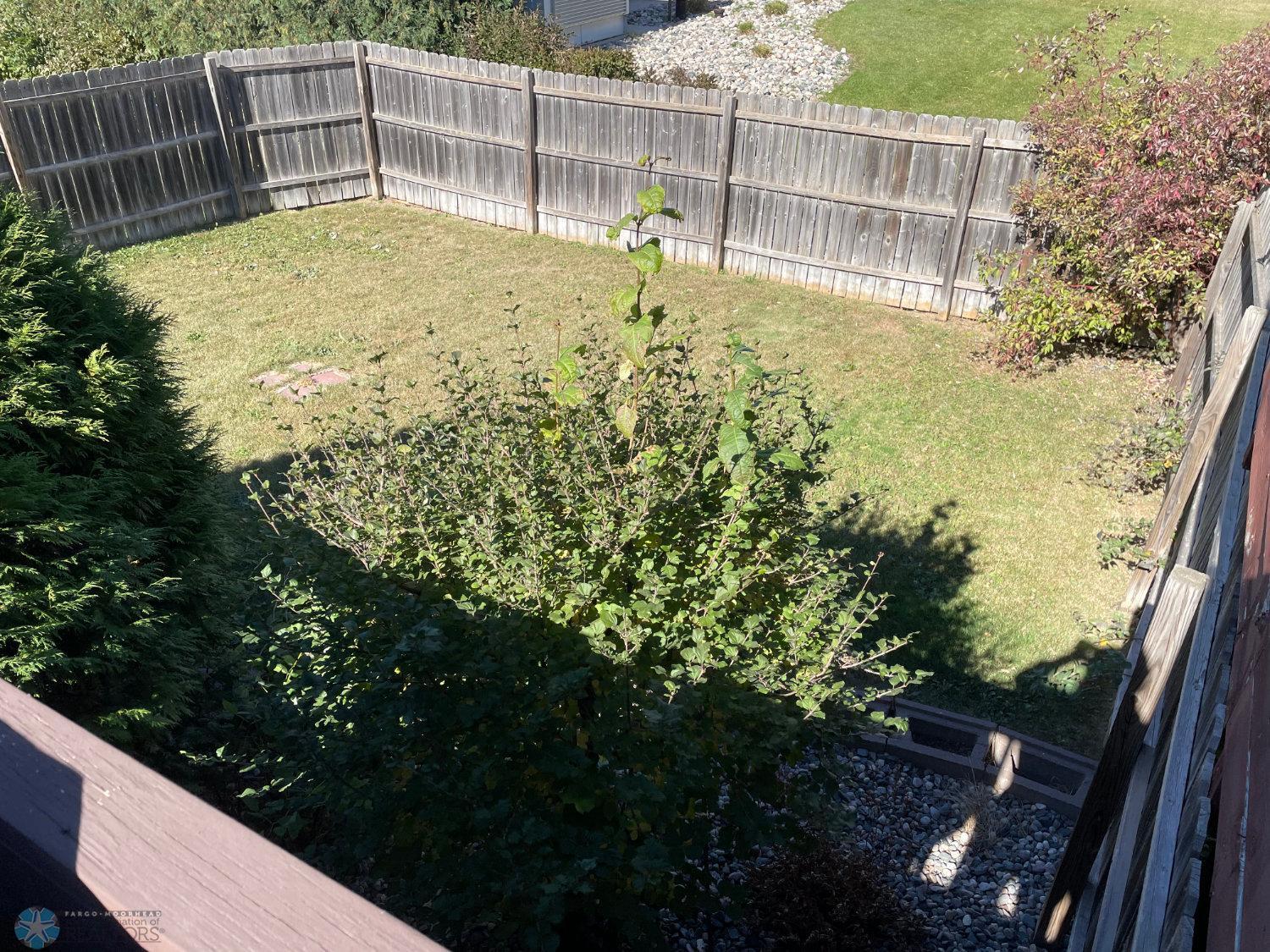 Fenced back yard viewed from deck.