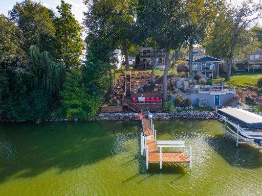 Terraced lakeside yard with variety of plants grasses trees boulders