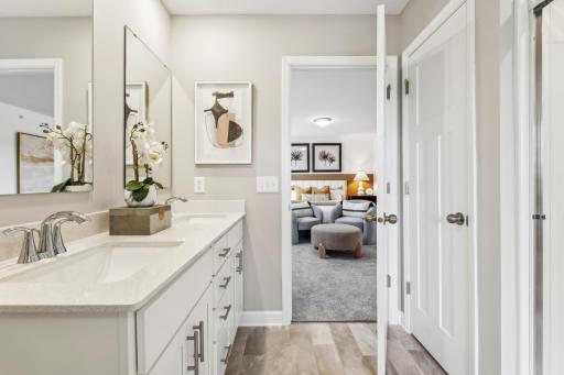 (Photo of a model home, actual homes finishes will vary) The spacious owner's ensuite bath features a double sink vanity with plenty of storage, a linen closet, and a shower.