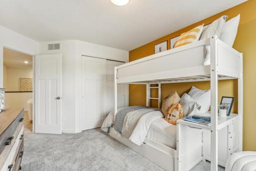 (Photo of a model home, actual homes finishes will vary) One of two generously sized upper level secondary bedrooms with spacious closets.