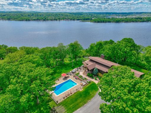 This custom 5 bed, 5 bath rambler impresses with exquisite woodwork by renowned craftsmen Al and Wally Hines, rustic white oak floors, & walls of windows that flood the home with natural light & views of the river.
