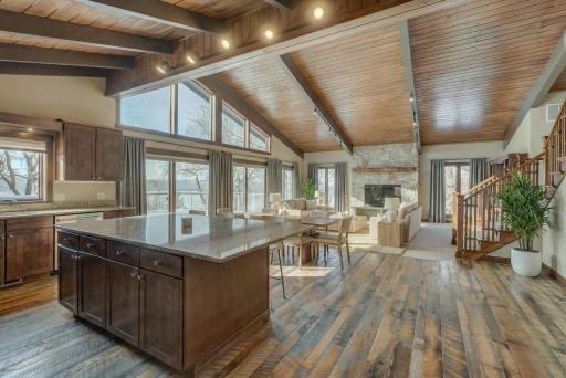 An open-concept main level is anchored by a striking stone, wood-burning fireplace in the living room and a gourmet kitchen. Cambria countertops, a generous pantry, and access to the expansive walkout deck for seamless indoor/outdoor living.