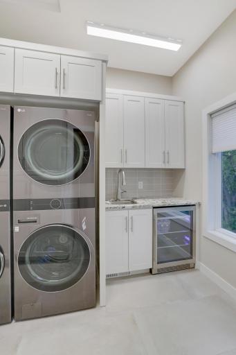 Sink and wine/water fridge upper level with all custom cabinetry
