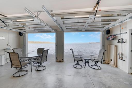 Lower level entertainment area opens up glass garage doors to the cement patio