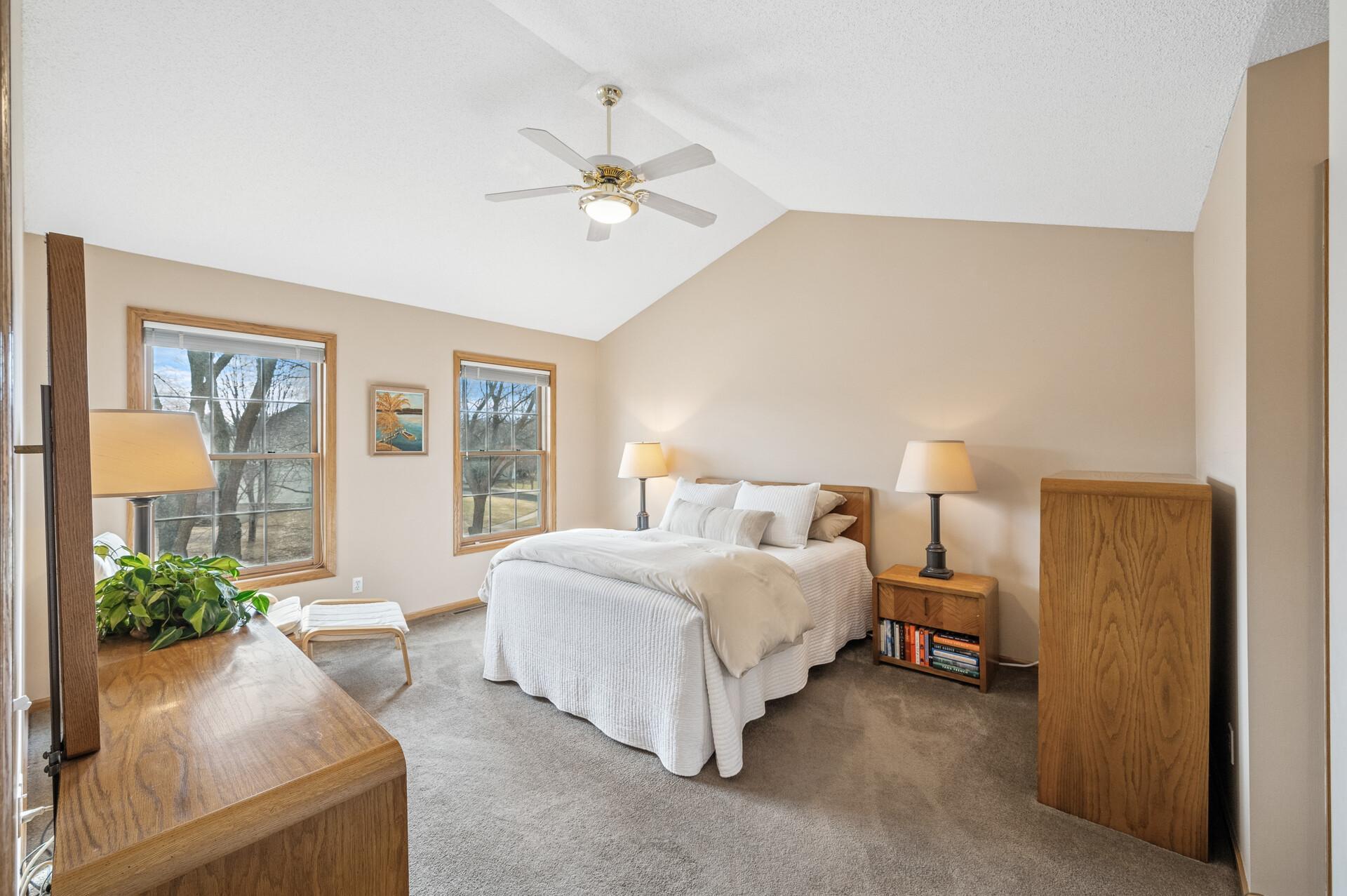 Primary bedroom with vaulted ceilings and is of ample size.