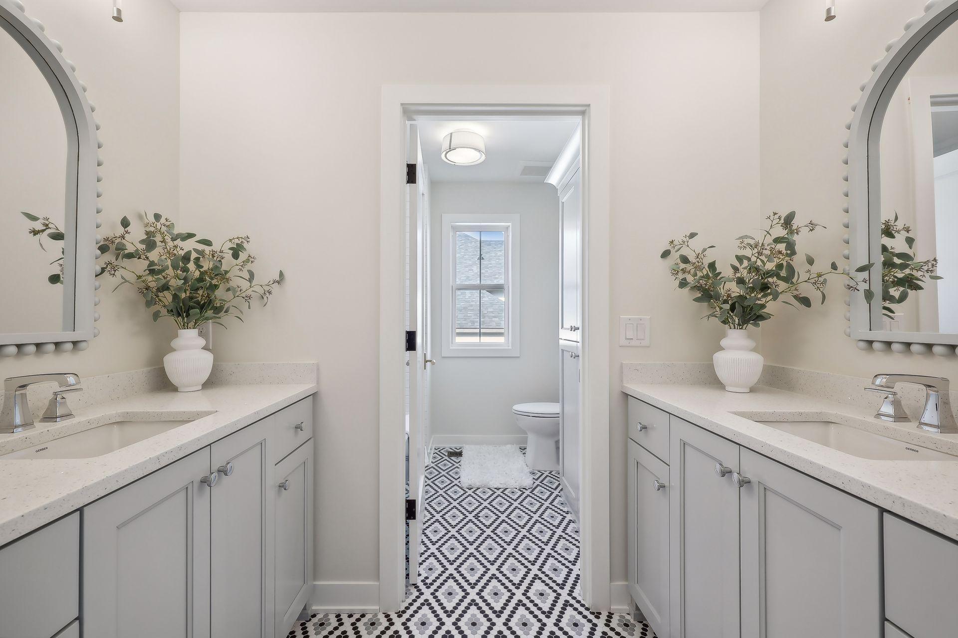 Enjoy the upper level's full bathroom, featuring arched mirrors, dual sinks, and abundant cabinet space.