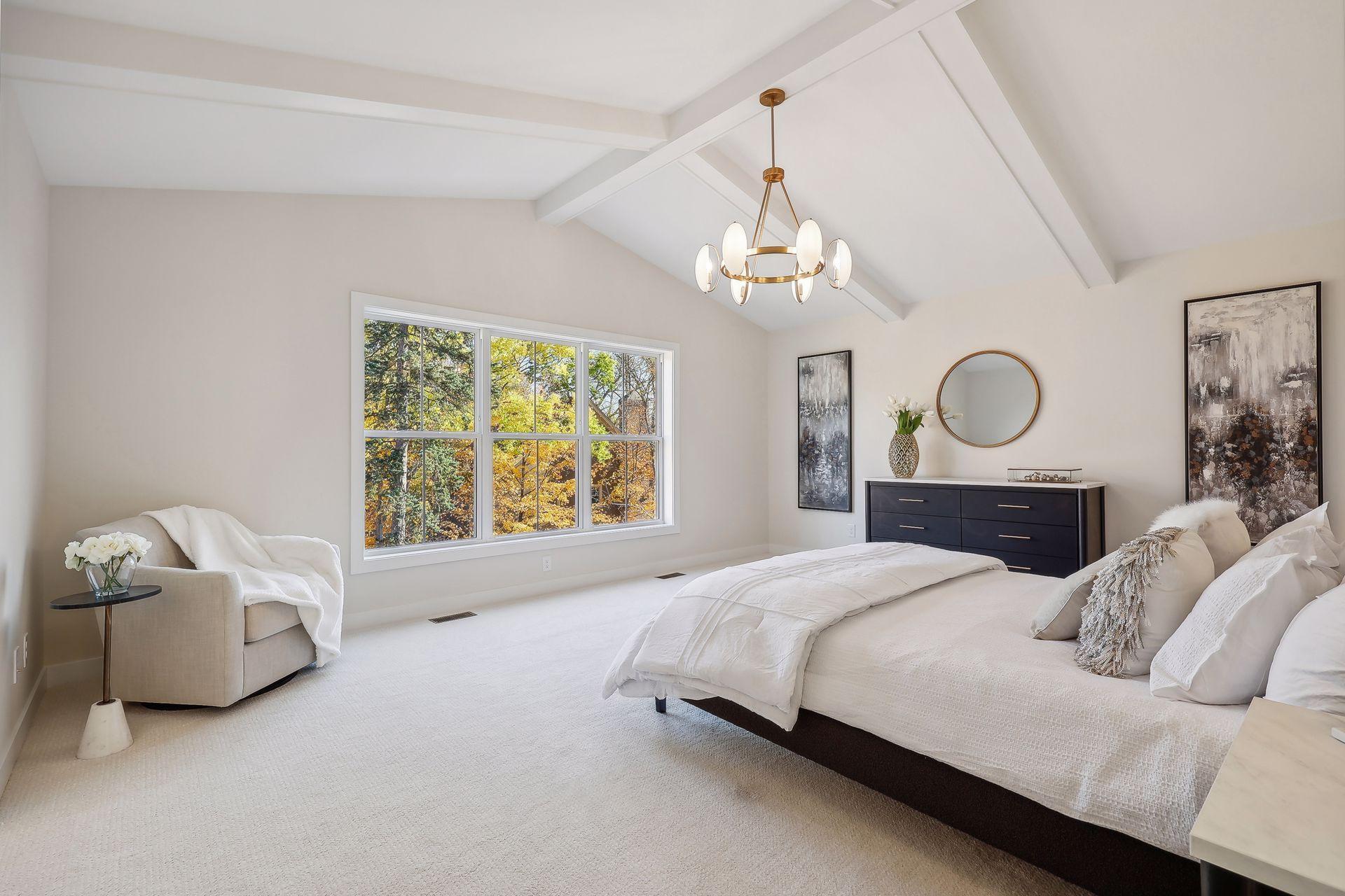 Retreat to the primary bedroom, featuring beamed vaulted ceilings and an abundance of natural light.