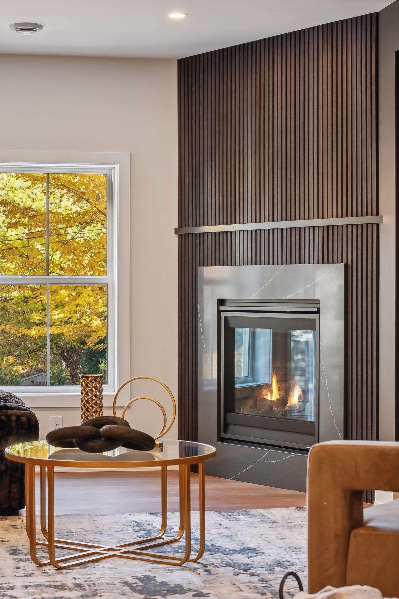 Unwind by the lower level fireplace, beautifully framed by a chic charcoal slatted wall.