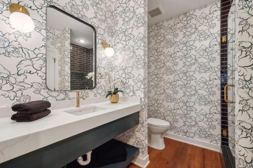 Discover the lower level 3/4 bathroom, featuring a sleek floating vanity with a convenient lower shelf for added storage.