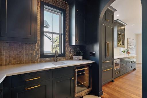 Back pantry includes sink, beverage fridge, and plentiful storage.