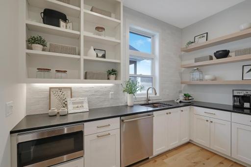 The butler's pantry includes a built-in microwave, additional dishwasher, additional sink, as well as cabinet and shelf space.