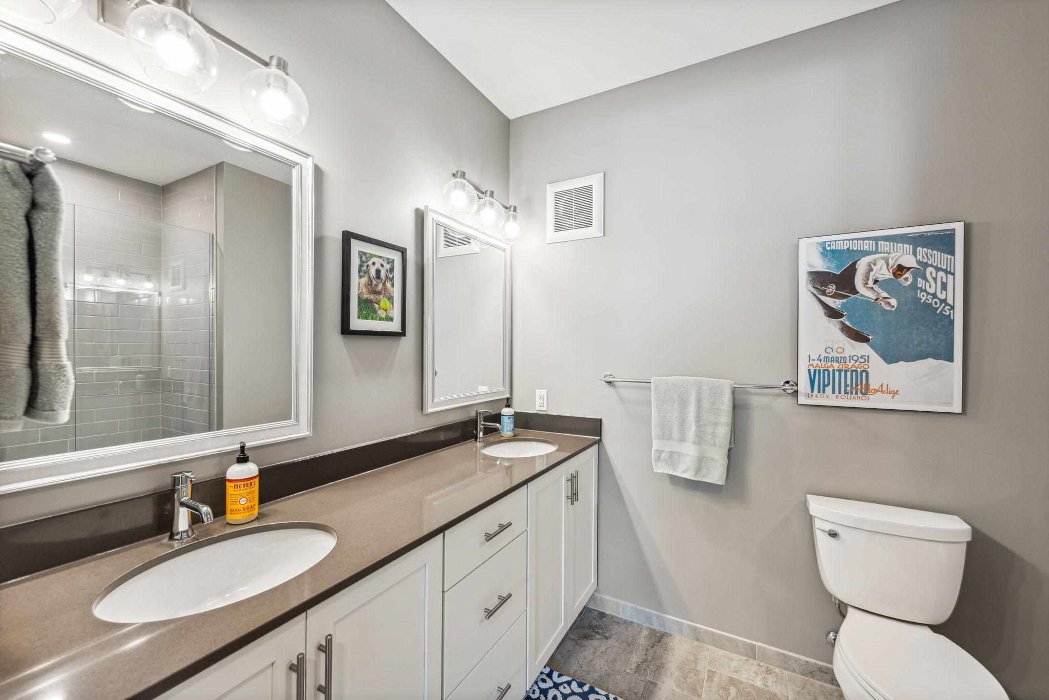 Beautiful ensuite primary bath with double vanity, Quartz countertops and walk in shower.