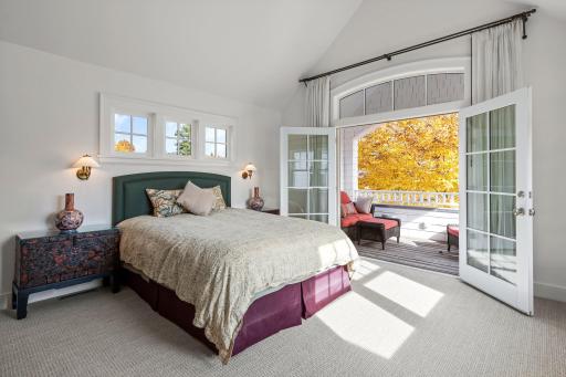 Vaulted primary suite with french doors opening to a covered balcony.