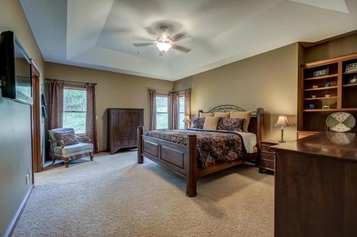 Private and relaxing primary suite offering charming built-ins, an ensuite bath with a jetted tub, and a spacious walk-in closet.