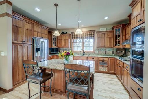 The gourmet kitchen shines with granite countertops, cherry cabinets, a spacious center island, and stainless steel appliances.