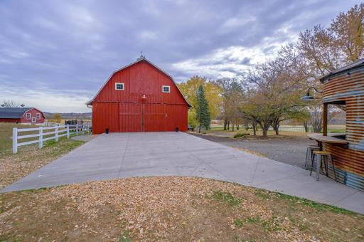 Outside, amenities like a charming grain bin bar, beautiful landscaping, an expansive patio, and ample parking space enhance the event experience.