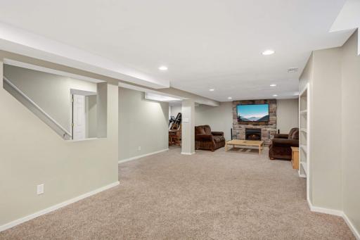 The expansive finished basement offers incredible versatility with large, wide-open family room space anchored by a cozy stone-surround gas fireplace.