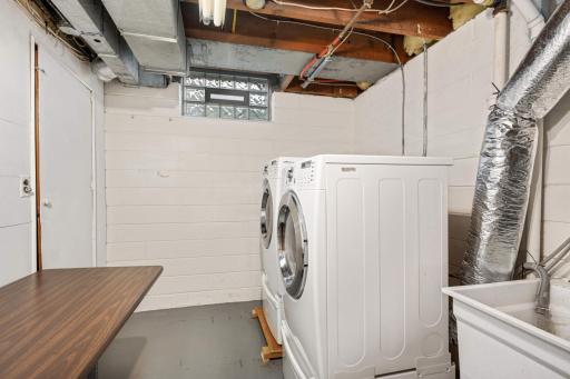 A clean laundry space with plenty of space for a folding table and great hanging space.