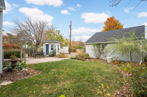 You'll love the darling cottage-style structure ideal for a potting shed or play house stepping directly onto a spacious patio for alfresco dining amid lush landscaping.