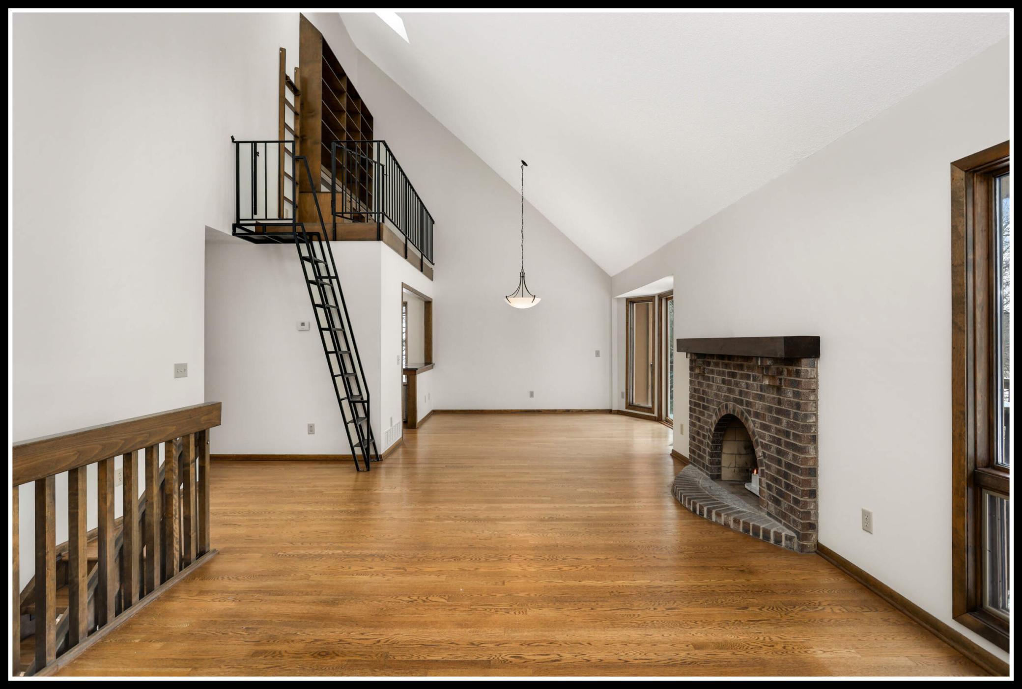 A brick-surround wood-burning fireplace adds a cozy ambiance to the upper level.