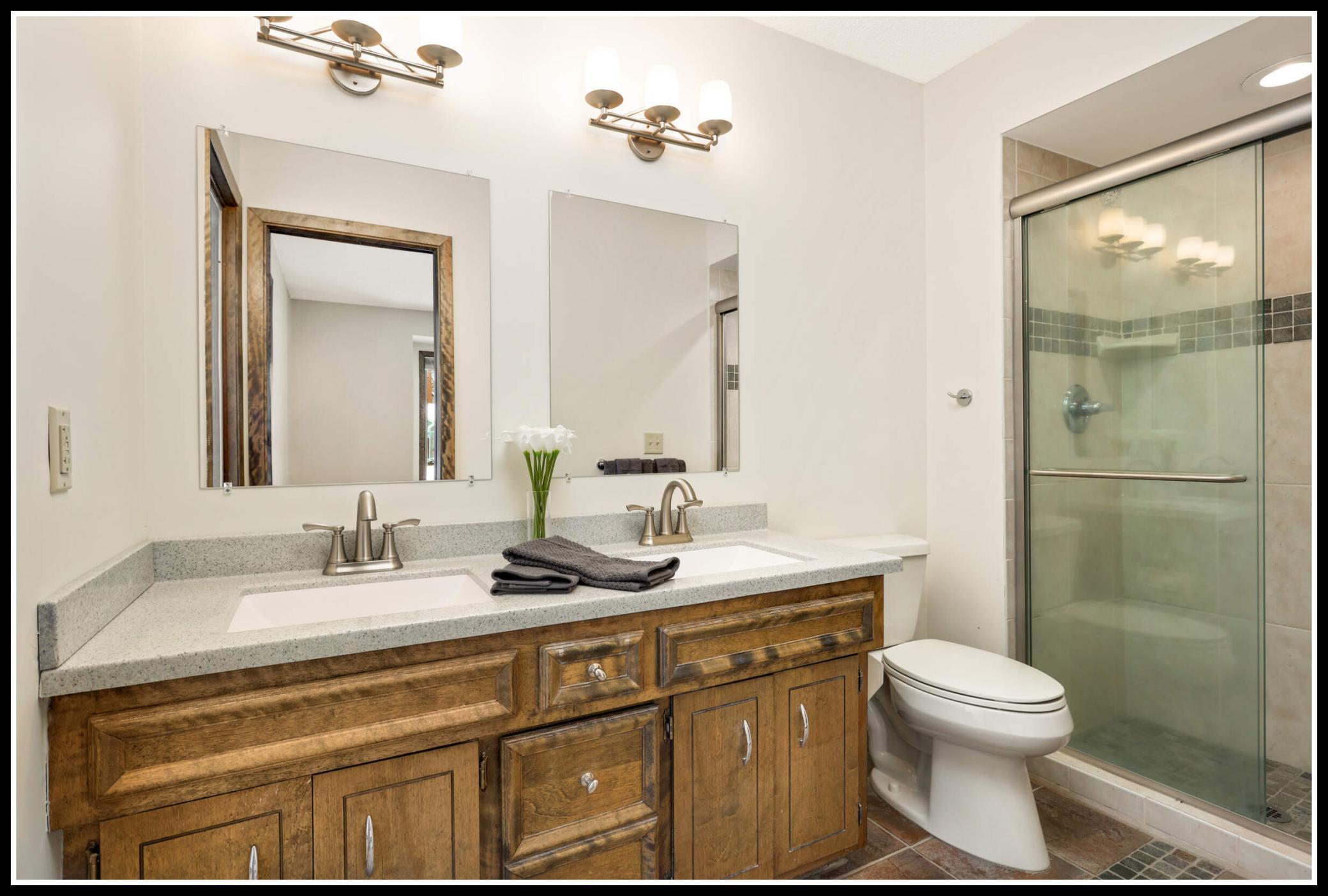 Private primary 3/4 bathroom with double sink vanity and walk-in shower