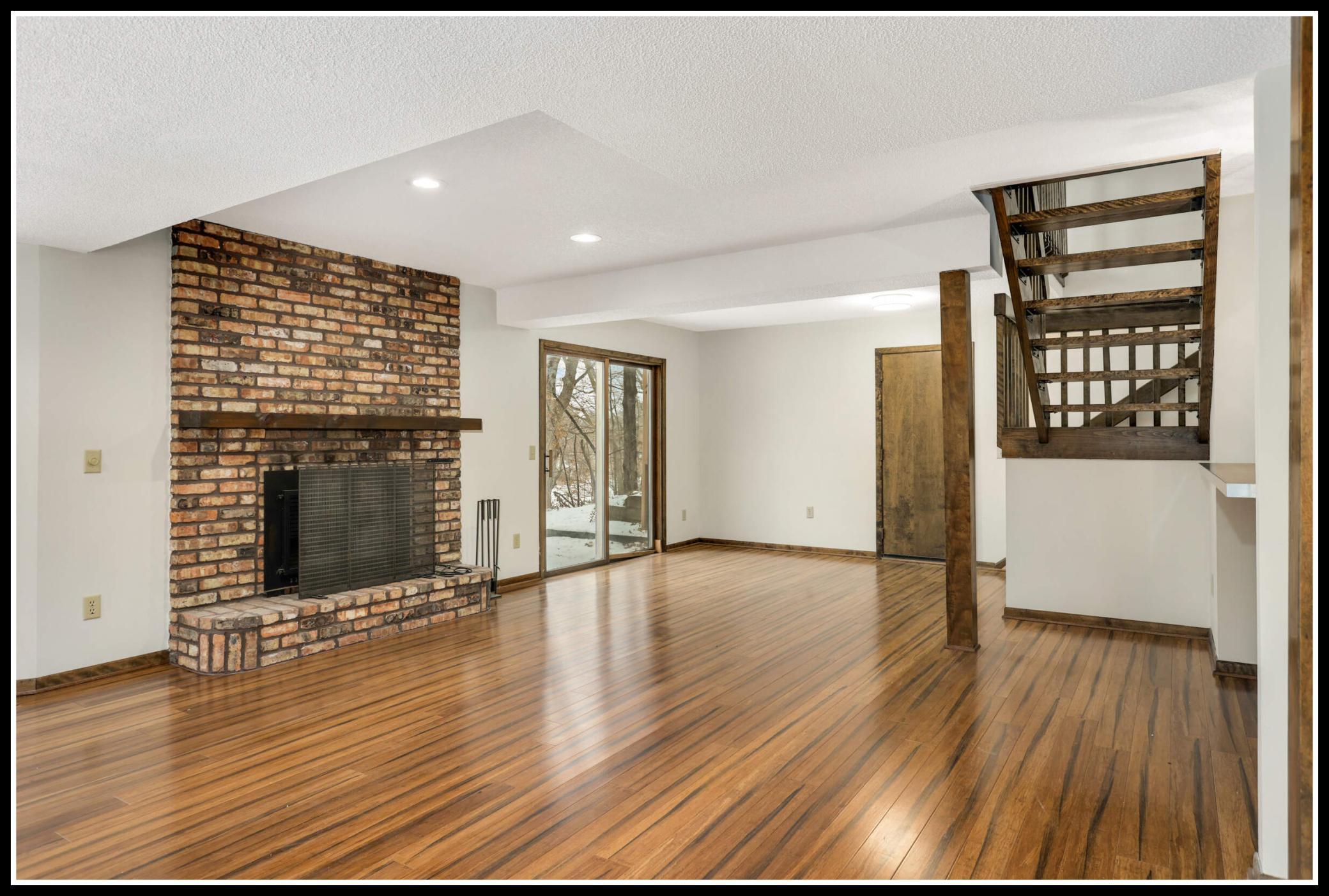 Another brick-surround wood-burning fireplace makes the lower level feel extra cozy