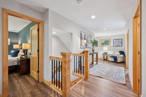 Upper level is bright and inviting with incredible millwork and wrought iron railing.