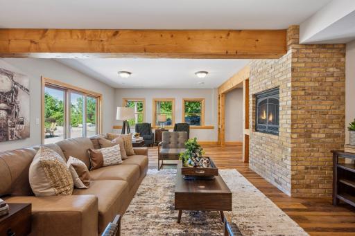 Gas fireplace with floor to ceiling brick surround & beamed ceilings.