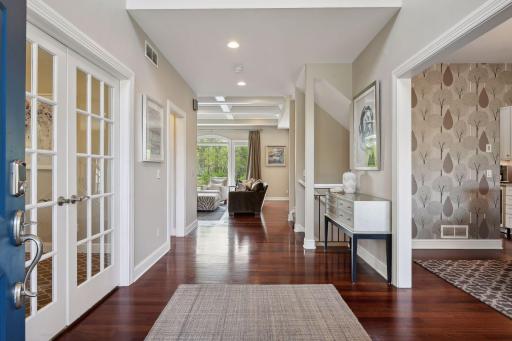 The spacious entryway flows naturally into the dining area and a separate office space with double glass french doors.