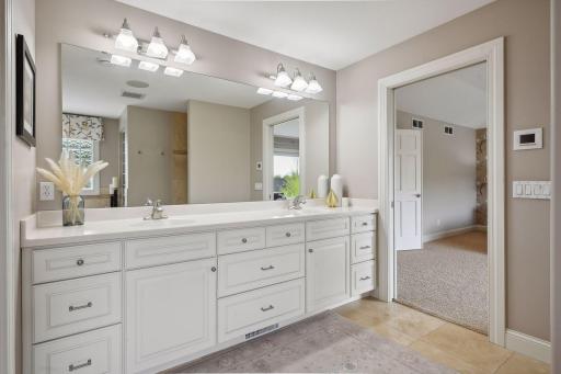 The large en suite primary bathroom features a double sink, walk in shower, soaking tub, and closet space.