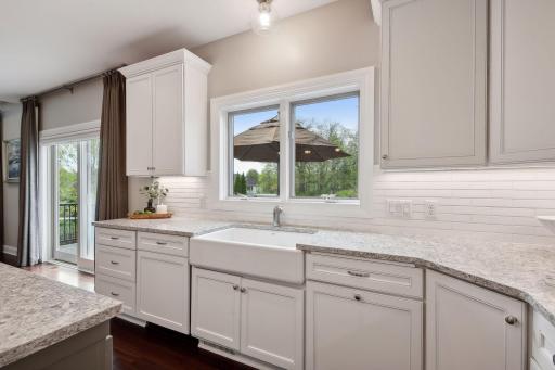 The cabinet covered dishwasher, farmhouse sink, and pull out garbage are functional yet sleek and fashionable.