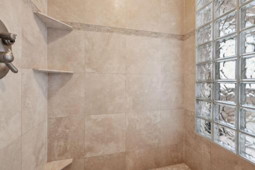 The walk in shower features floor to ceiling tile.