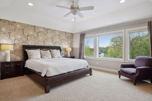 The spacious primary bedroom features oversized windows overlooking the backyard.