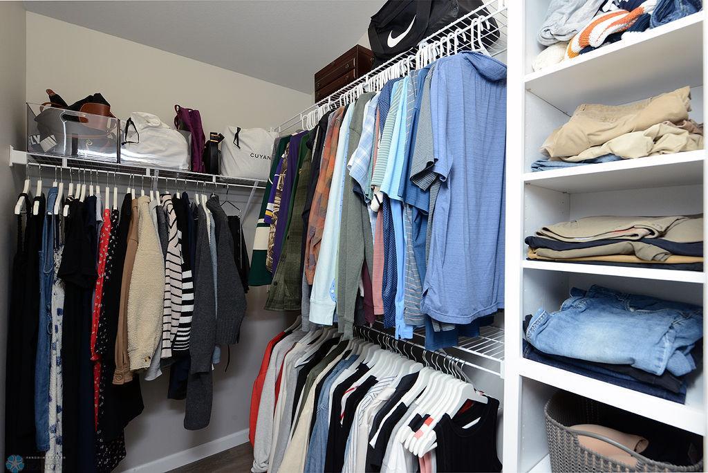Primary walk in closet with built in shelves
