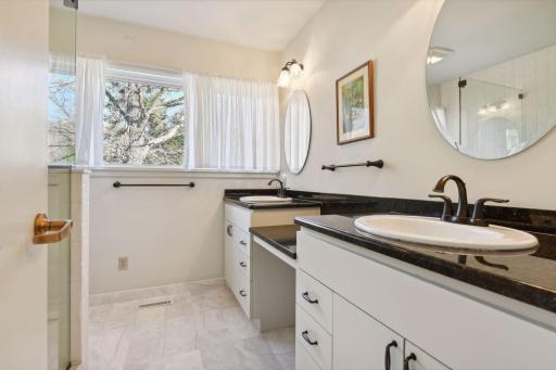 The primary bath has been updated with granite topped double vanities and a heated tile floor