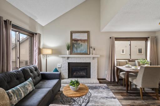 The fireplace is a stunning focal point in the living room, beautifully designed to complement the soaring vaulted ceilings that enhance the sense of space and grandeur.
