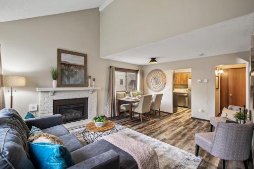 The living room exudes warmth and sophistication, centered around a stunning fireplace that serves as the heart of the space.