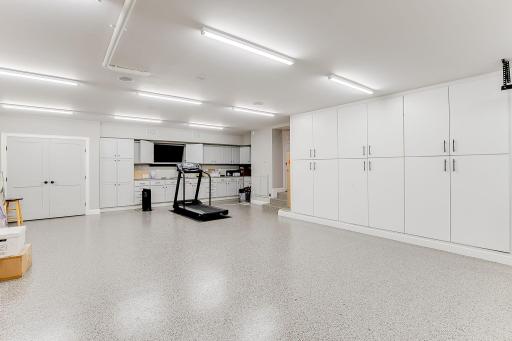 Spancrete garage/workshop in lower level below main garage. Sound & tv system. Epoxy floors, workbench w/sink & cabinets galore. Garage door leads you to the backyard patio. Heated floor drain. Lots of lighting! Access from main garage or home.