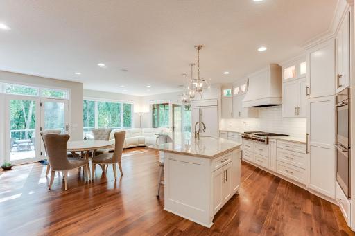 The heart of the home ~ Chef's Dream Kitchen recently extensively remodeled. Professional grade appliances, craftsman cherry 5" plank floors, custom enameled cabinets with upper glass fronts and interior lighting, stylish lighting.