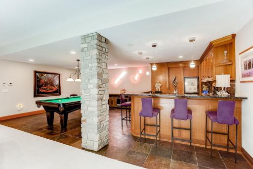 Full custom wet bar complete with slate floor, wine racks, glass front cabinets, granite, microwave, dishwasher, refrigerator, sink, and hot water dispenser. Spacious room to entertain or shoot some pool.