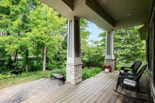 Covered porch with headboard ceiling, sound system and IPE decking, natural stone accents, paver walkway.