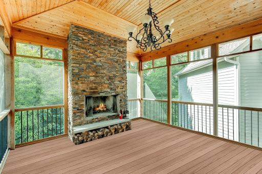 Three season porch with ledger stone, wood burning fireplace. Fully screened with custom poly covers for winter to turn it into a 3 season porch. Tigerwood flooring and wood ceiling. Walks out to the deck.