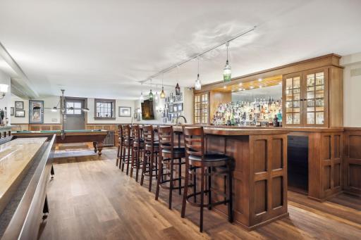 The lower level renovation features a custom full sized bar with all the necessary accessories: built-in cabinetry, a prep sink, ice maker, dishwasher, and beverage coolers. Shuffleboard table included in sale.